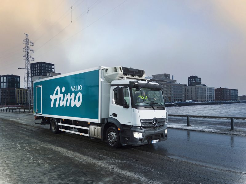Kuvassa talvisessa Helsingin maisemassa on Valio Aimo rekka-auto kuvattuna sivuttain ajamassa eteenpäin tiellä.